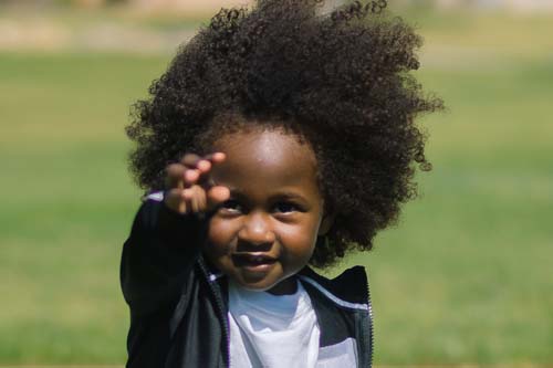 Child on gradd pointing at camera